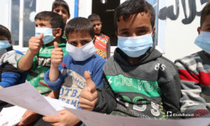 أطفال يرتدون الكمامات أثناء نشاط للتوعية بمخاطر فيروس 