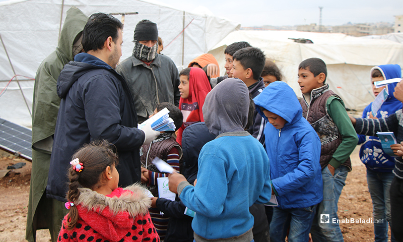 حملة منظمة "بادر" التطوعية لتوعية سكان مخيم في مدينة عفرين من أجل الوقاية من فيروس "كورونا المستجد"، عبر توزيع المنشورات- 18 من آذار (عنب بلدي)