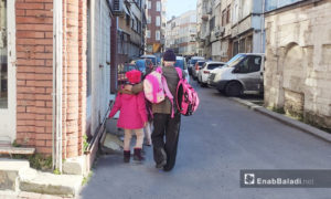 رجل يصطحب حفيدته إلى المنزل بعد انتهاء الدوام المدرسي (عنب بلدي)