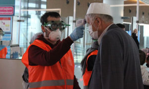 فحص مواطن تركي عائد من العمرة في إحدى المطارات التركية-(الأناضول)