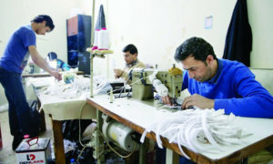 سوريون يعملون في ورشة خياطة في تركيا (يني شفق)