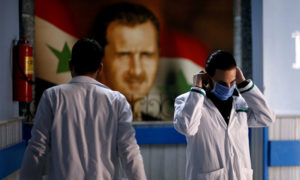 عامل صحي يرتدي كمامة داخل أحد مشافي دمشق (رويترز)