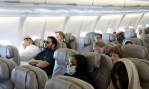 ركاب يضعون كمامات على وجوههم للوقاية من فيروس كورونا على متن طائرة تابعة لشركة الخطوط الجوية السعودية 2020 (رويترز)