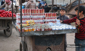 طفل يبيع منتجات معلبة على عربته في سوق مدينة إدلب- 7 من نيسان (عنب بلدي)