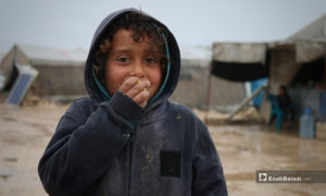 طفل بمخيم حلب لببيه يأكل الطعام في الأجواء الماطرة- 24 من نيسان (عنب بلدي)