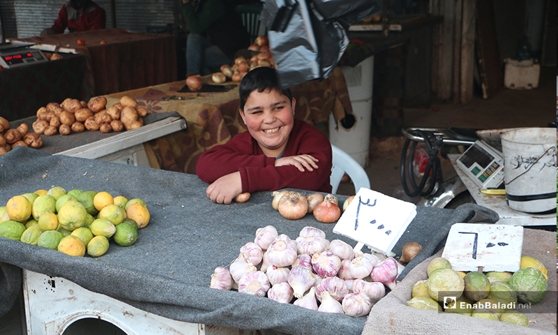 طفل يبيع الثوم في سوق مدينة إدلب- 7 من نيسان (عنب بلدي)