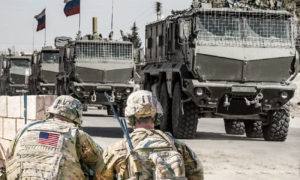 جنود أمريكيون ينظرون إلى عربات عسكرية روسية (تعديل عنب بلدي)
