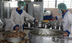 عمال إغاثة يوزعون الحصص الغذائية في أحد المطابخ الرمضانية في إدلب - 1 أيار 2020 (عنب بلدي)
