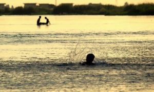 طفل يسبح في منطقة بين الجسرين في محافظة الرقة (عنب بلدي)