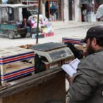 بائع يقرأ القرآن أمام عربته في أحد أسواق مدينة الباب 4 من أيار 2020 (عنب بلدي)