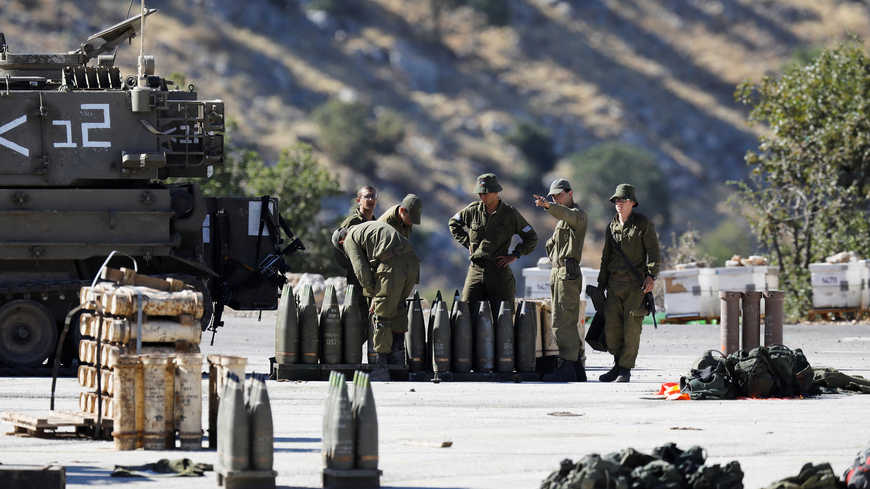 جنود إسرائيليون يقفون بجوار قذائف ووحدة مدفعية متنقلة بالقرب من الجانب الإسرائيلي من الحدود مع سوريا في مرتفعات الجولان التي تحتلها إسرائيل- 26 من آب 2019 (رويترز)