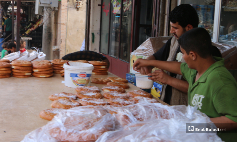 بائع يرش جوز الهند على المعروك أحد الأطعمة الأساسية والمعروفة في رمضان، مارع ريف حلب - 20 أيار 2020 (عنب بلدي/ عبد السلام مجعان)