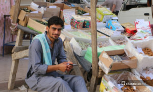 بائع بجوار بسطة لبيع حلويات عيد الفطر في مدينة مارع بريف حلب - 20 أيار 2020 (عنب بلدي/ عبد السلام مجعان)