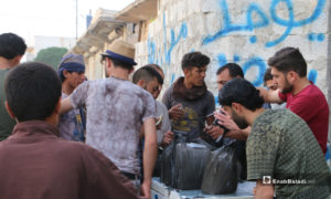 شبان يشترون ألواح البوظ، إذ زاد الطلب عليها بعد ارتفاع درجات الحرارة - 20 أيار 2020 (عنب بلدي/ عبد السلام مجعان)