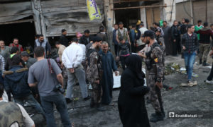 عناصر الشرطة يبعدون الأهالي الذين تجمعوا بالقرب من انفجار عبوة ناسفة في محل خضار بمدينة الباب - 10 أيار 2020 (عنب بلدي)