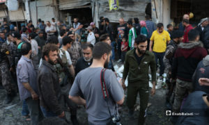 عناصر الشرطة يبعدون الأهالي الذين تجمعوا بالقرب من انفجار عبوة ناسفة في محل خضار بمدينة الباب - 10 أيار 2020 (عنب بلدي)