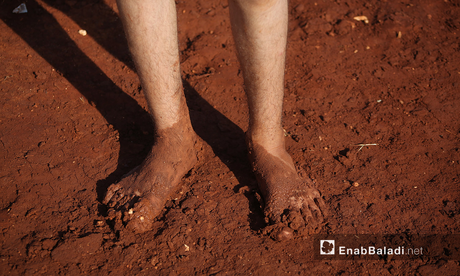 قدما طفل مغمورتان بالوحل بعد العاصفة المطرية التي ضربت مخيم "سهل الخير" في كفربني بريف إدلب الشمالي - 19 حزيران 2020 (عنب بلدي/يوسف غريبي)