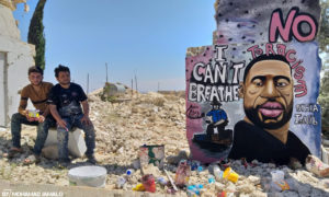 الفنان عزيز أسمر بجانب لوحته الجدارية المتضامنة مع الأمريكي الذي قتل على يد الشرطة خنقًا، جورج فلويد- 1 من حزيران (عزيز أسمر/فيس بوك)