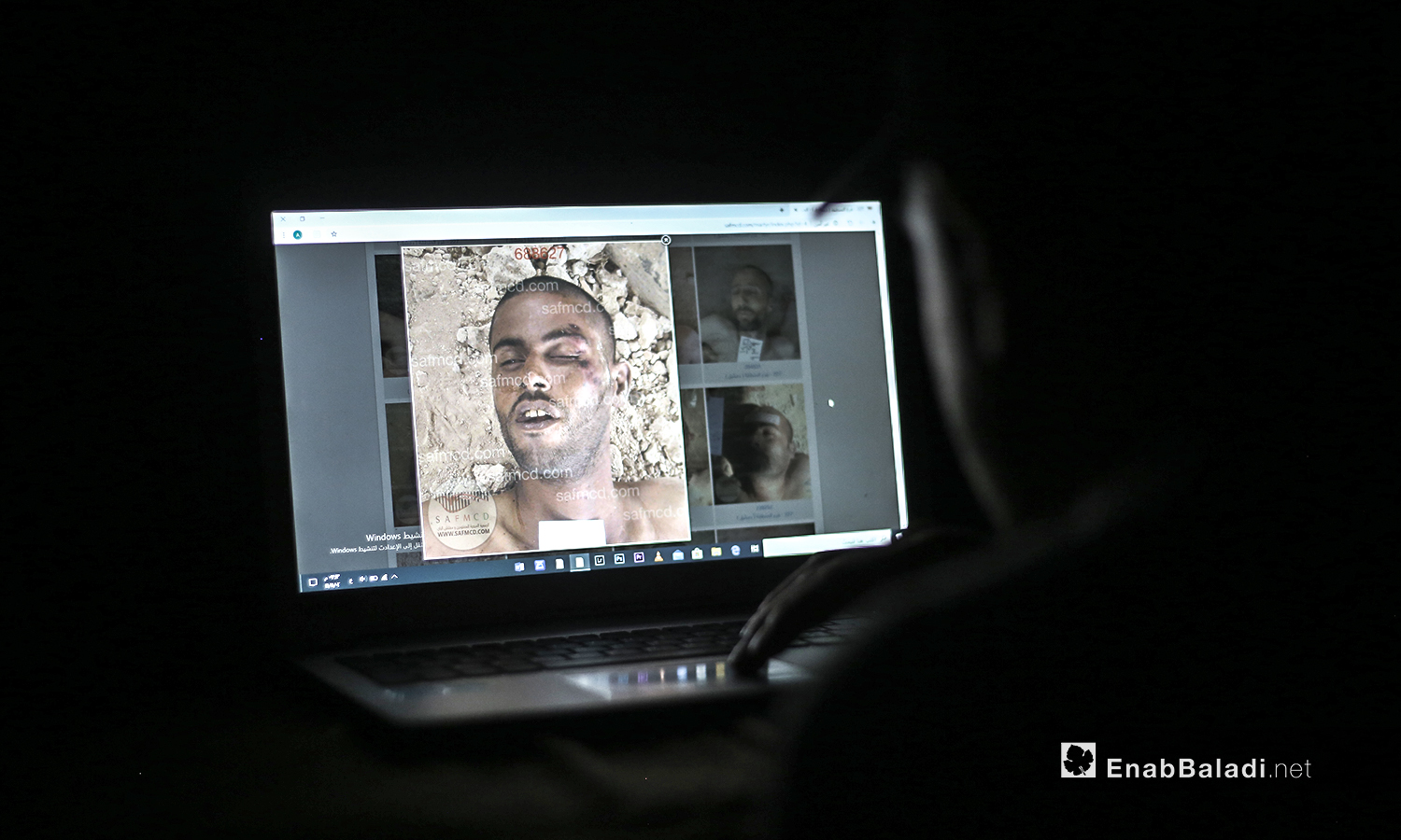 شخص يحاول التعرف على أحد أقربائه المختفي في سجون النظام السوري من خلال الصور المسربة من قيصر - 13 من تموز 2020 (عنب بلدي / يوسف غريبي )