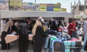 نساء يشترون ألبسة من على البسطات في أسواق مدينة الرقة - 30 تموز 2020 (عنب بلدي / عبد العزيز الصالح )