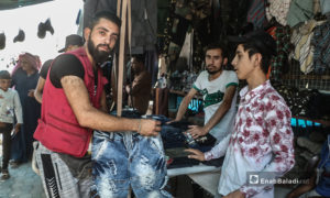 شاب يشتري الثياب من أحد محال الألبسة في أسواق مدينة الرقة - 30 تموز 2020 (عنب بلدي / عبد العزيز الصالح )