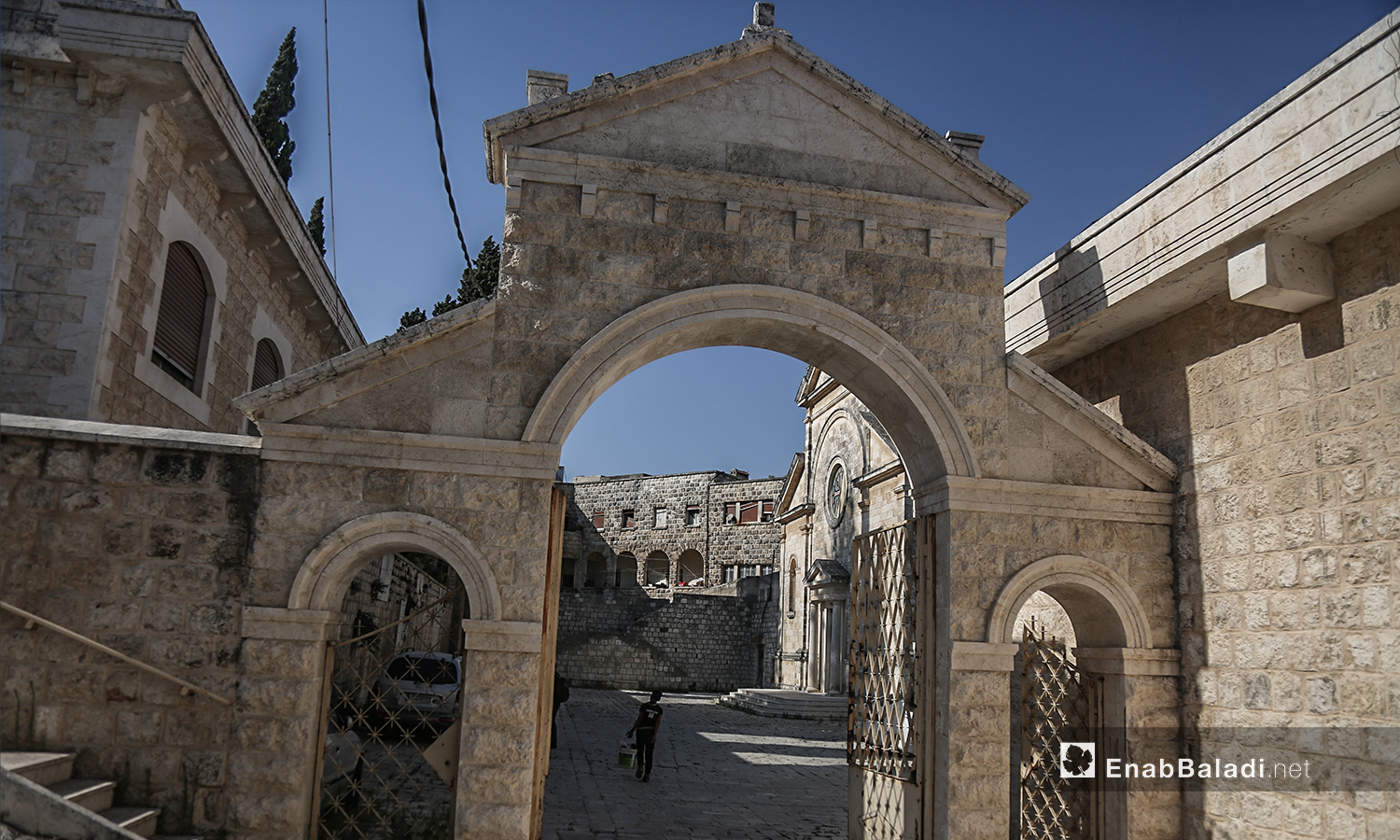 الباب الحجري لكنيسة "مار يوسف" يوصل إلى باحتها الخلفية - تموز 2020 (عنب بلدي)