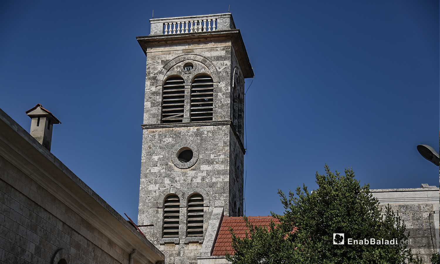 برج كنيسة "مار يوسف" يطل على قرية القنية - تموز 2020 (عنب بلدي)