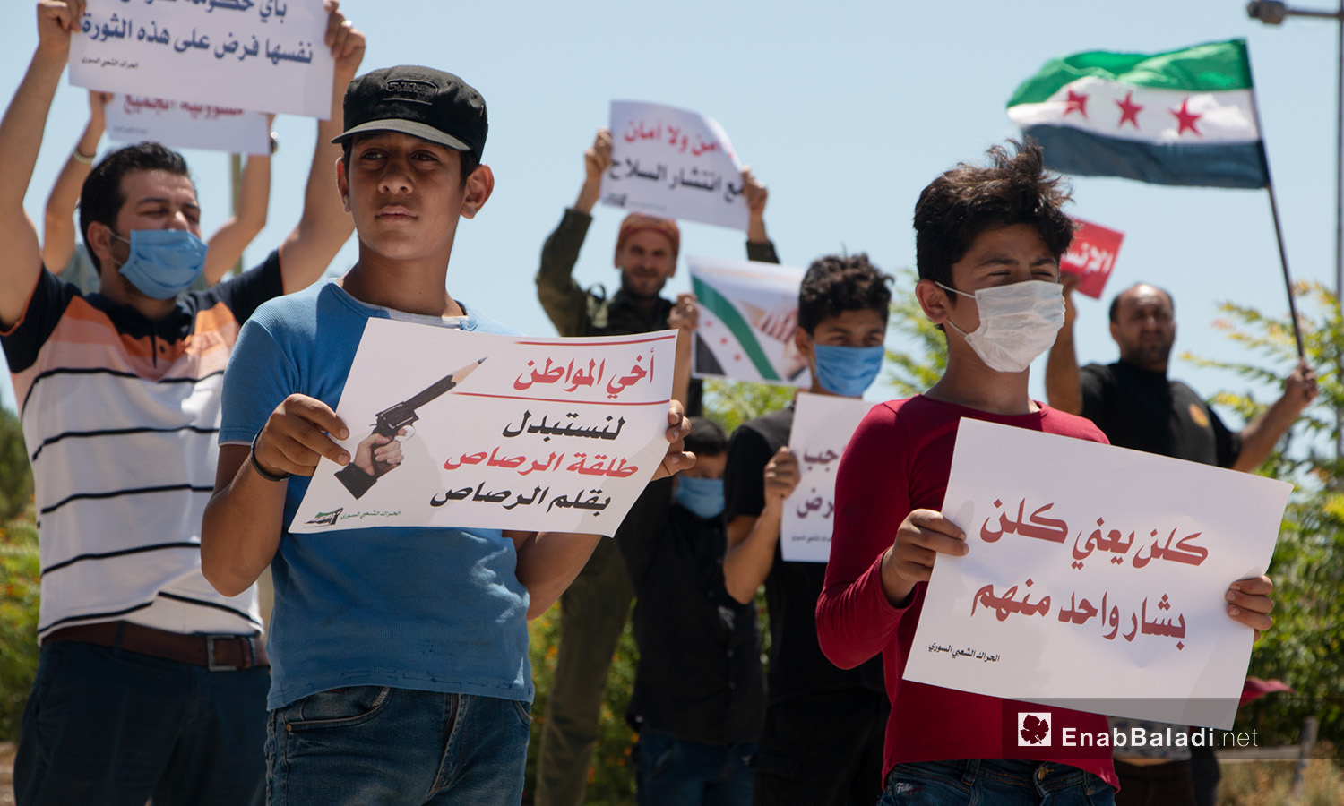 أطفال وشبان يحملون لافتات في وقفة احتجاجية بمدينة إدلب - 17 تموز 2020 (عنب بلدي/أنس الخولي)