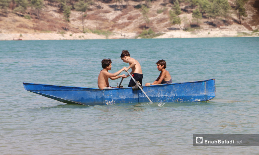 أطفال يقودون قاربًا في بحيرة ميدانكي في عفرين شمالي سوريا - 21 اموز 2020 (عنب بلدي/عبد السلام مجعان)
