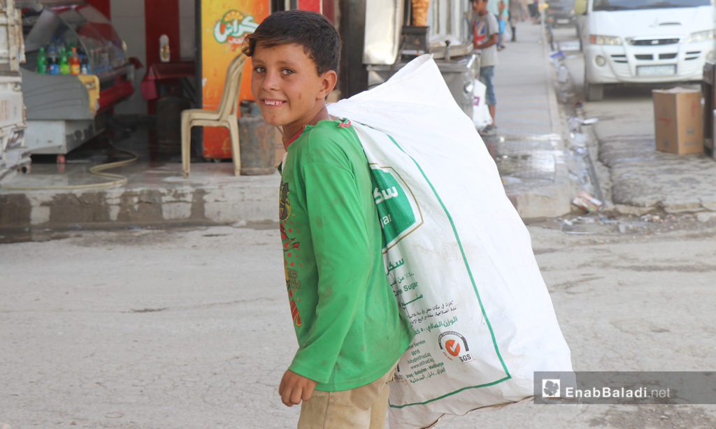 طفل يحمل كيسًا في مدينة الرقة - 26 تموز 2020 (عنب بلدي/عبد العزيز الصالح)