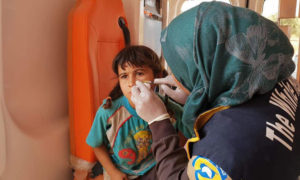 متطوعة في الدفاع المدني السوري تعالج طفلة مصابة 
