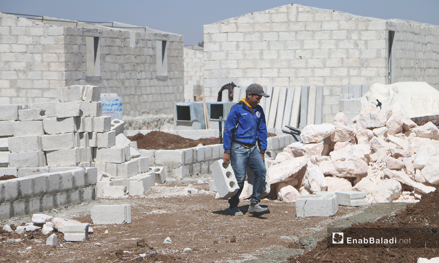 عامل بناء ضمن مشروع الكتل السكنية عوضًا عن الخيام في قرية بحورته بريف حلب الشمالي - 26 حزيران 2020 (عنب بلدي/عبد السلام مجعان)
