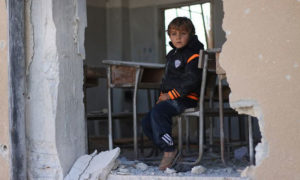 طفل جالس في مدرسة مدمرة - 2016 (يونسيف)
