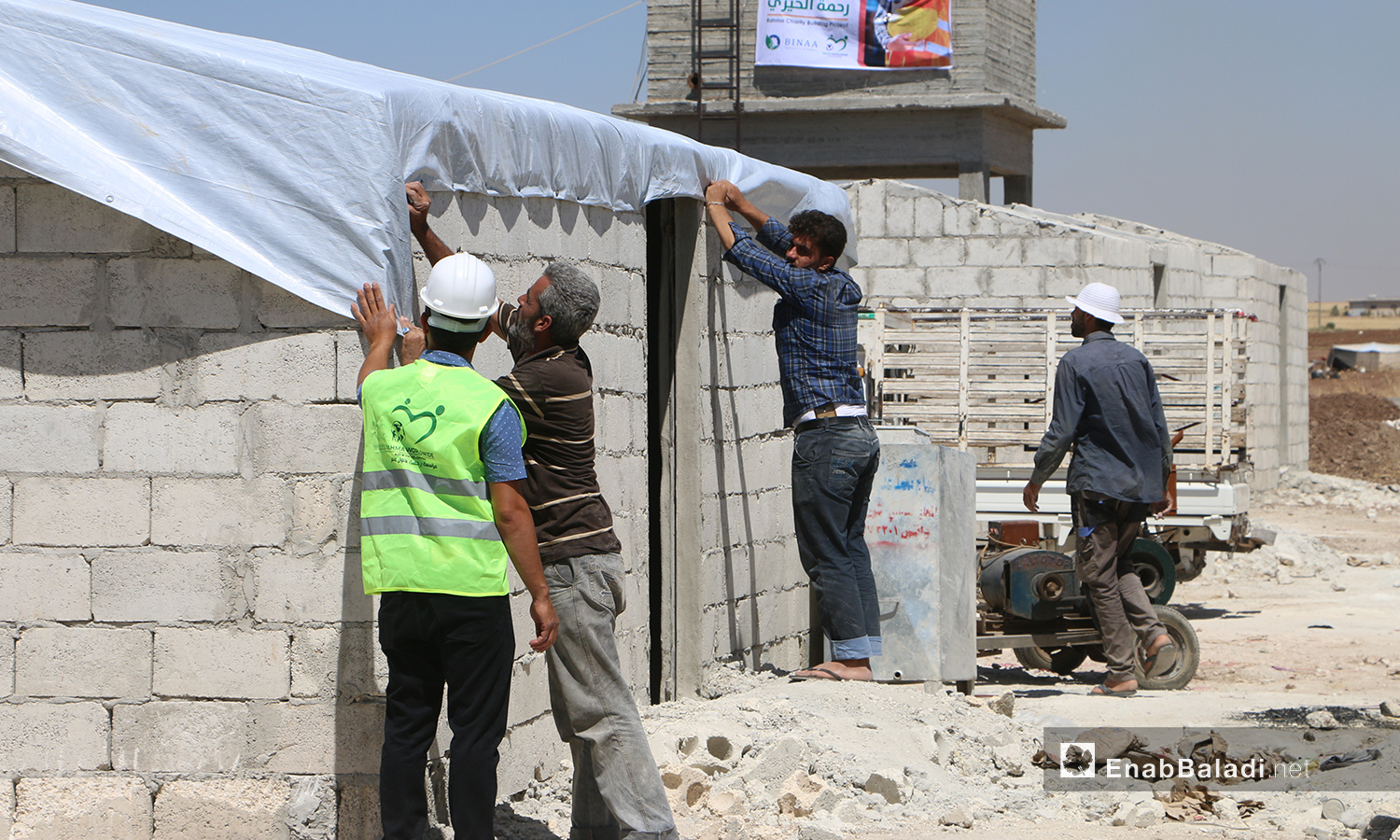 عمال بناء ضمن مشروع الكتل السكنية عوضًا عن الخيام في قرية بحورته بريف حلب الشمالي - 26 حزيران 2020 (عنب بلدي/عبد السلام مجعان)
