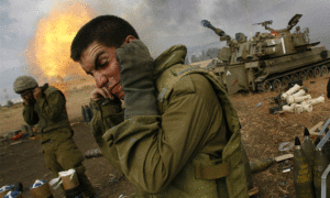 جنود إسرائيليون يغطون آذانهم عندما تطلق وحدة مدفعية قذائف باتجاه جنوب لبنان في "حرب تموز 2006" - "فرانس برس"