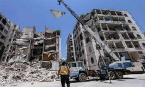 فرق الدفاع المدني في إدلب تزيل بقايا أسقف أحد الأبنية المدمرة جزئيًا  خشية سقوطه - 12 تموز 2020 (صفحة هاي إدلب في فيس بوك)