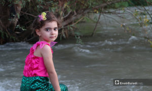 طفلة تجلس على ضفة نهر حنة في عفرين - 7 آب 2020 (عنب بلدي/ عاصم الملحم)