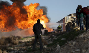 عناصر من الدفاع المدني يخمدون حريقًا في مصفاة بدائية لتكرير النفط في معرة النعمان بإدلب - 10 آذار 2020 (رويترز)