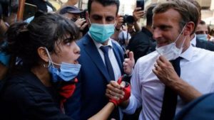 الرئيس الفرنسي إيمانويل ماكرون يستمع لشهادة مواطنة خلال زيارته لشارع مدمر في بيروت - 6 من آب 2020 (AP)