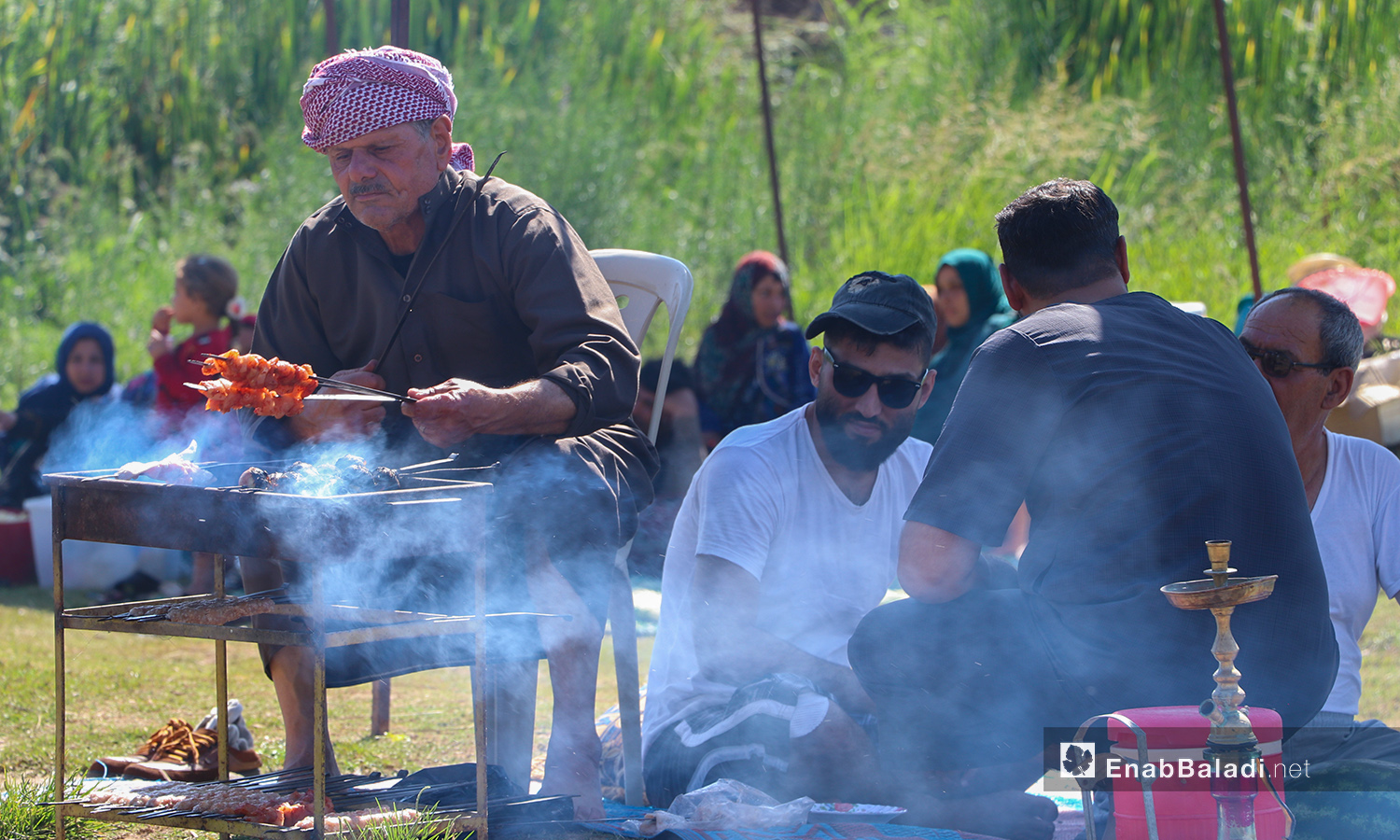 عائلة يحضرون الطعام على ضفة نهر حنة في عفرين - 7 آب 2020 (عنب بلدي/عاصم الملحم)