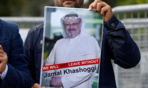 متظاهر يحمل صورة الصحفي جمال خاشقجي أمام القنصلية السعودية في إسطنبول (رويترز)