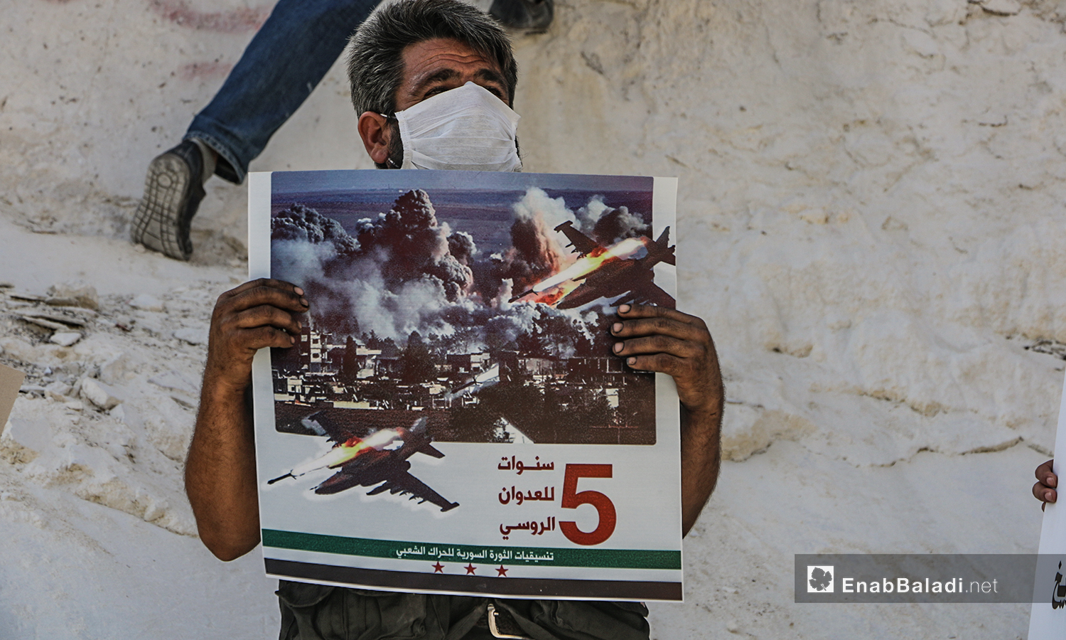 ناشط  في إدلب يحمل لافتة تستنكر الانتهاكات الروسية في سوريا خلال خمس أعوام من التدخل العسكري - 30 أيلول 2020 (عنب بلدي/أنس الخولي)