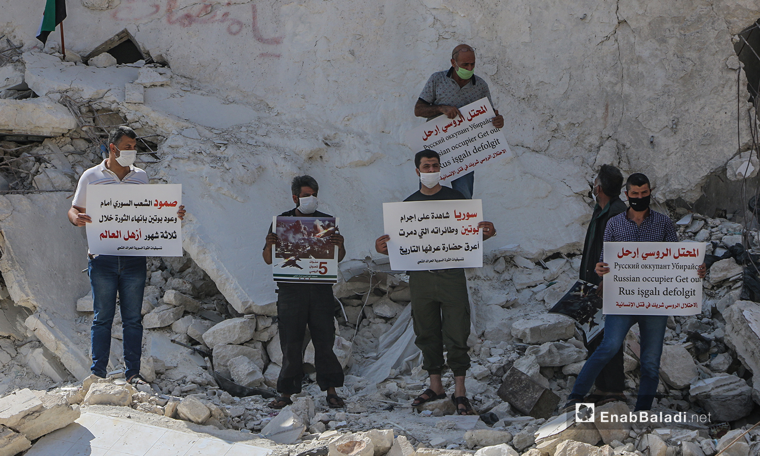 ناشطون في إدلب يحملون لافتات تستنكر الانتهاكات الروسية في سوريا خلال خمس أعوام من التدخل العسكري - 30 أيلول 2020 (عنب بلدي/أنس الخولي)