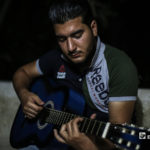 مازن الشيخ يعزف على الجيتار في منزله ببلدة عقربات شمال مدينة إدلب -08 أيلول 2020 (عنب بلدي/ يوسف غريبي)

