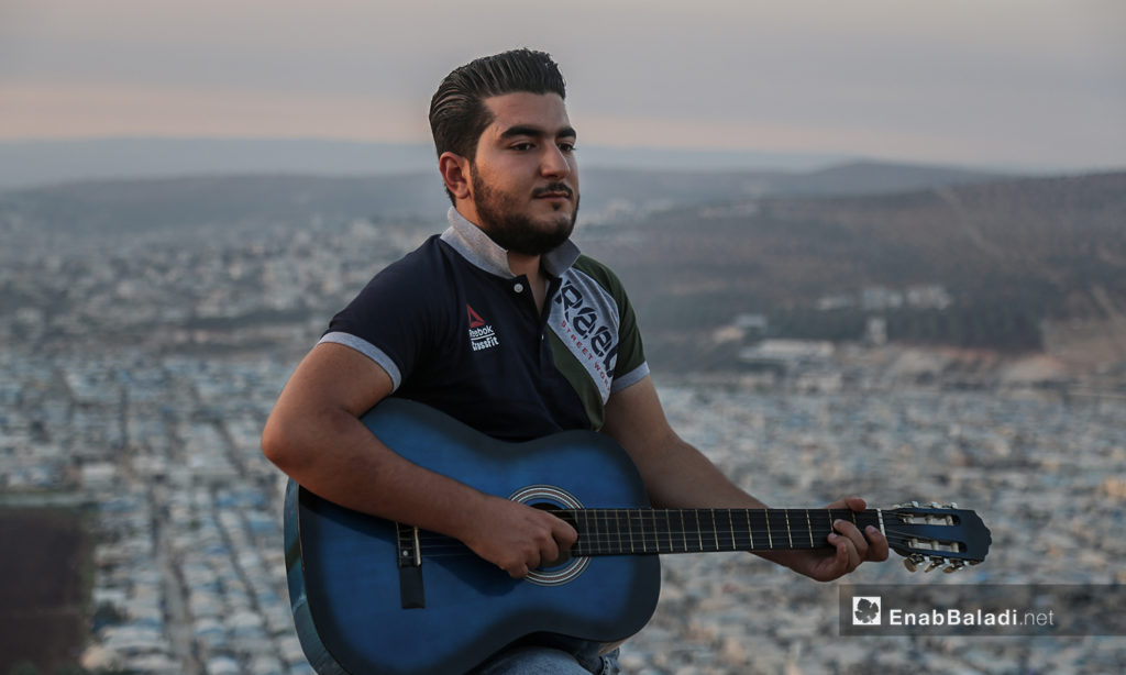 مازن الشيخ يعزف على تله بلدة عقربات المطلة على المخيمات والقرى -08 أيلول 2020 (عنب بلدي/ يوسف غريبي)