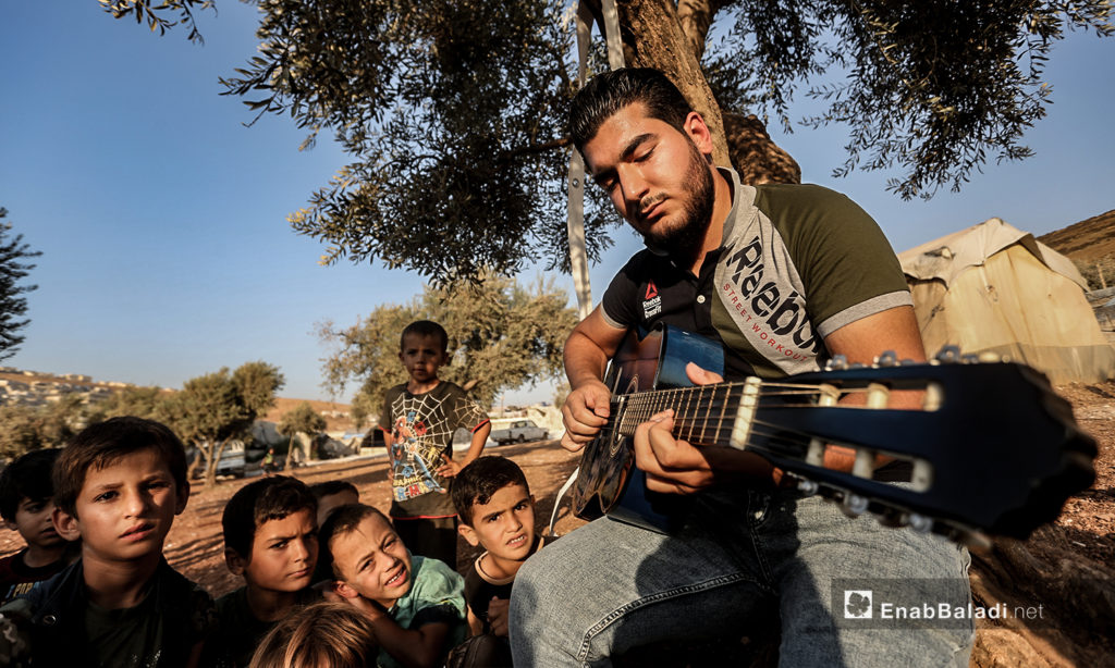 مازن الشيخ يعزف في مخيم بالقرب من بلدة عقربات شمال إدلب-08 أيلول 2020 (عنب بلدي/ يوسف غريبي)