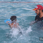 مدرب يساعد طفلًا على تعلم السباحة - أيلول 2020 (عنب بلدي/ إياد عبد الجواد) 