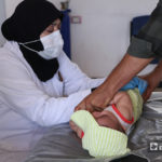 ممرضة تفحص الطفل لتلقيحه في مركز الباب الصحي - 22 أيلول 2020 (عنب بلدي/ عاصم الملحم)
