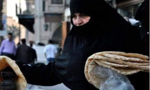 امرأة تحمل الخبز بعد شراءه من فرن في دمشق 27 من أيلول 2020 (فيس بوك)