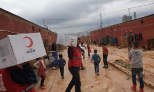 عناصر من الهلال الأحمر التركي أثناء توزيع مساعدات في سوريا (الموقع الرسمي للمنظمة)